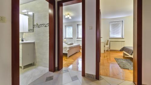 萨格勒布Central Apartment Smiley - FREE PARKING的走廊上设有浴室,房间内设有一张床