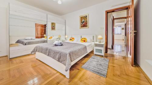 萨格勒布Central Apartment Smiley - FREE PARKING的一间卧室配有两张床和镜子
