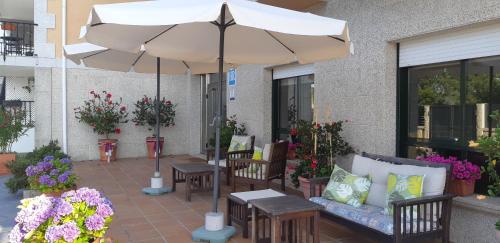 桑亨霍Hotel Cachada的一个带遮阳伞、椅子和鲜花的庭院