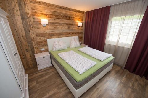 魏森湖Appartements Herwig Schwarzenbacher的一间卧室设有一张床和木墙