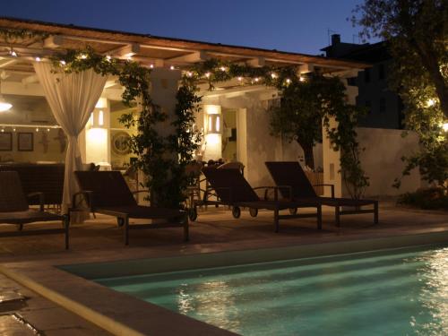 法萨诺Masseriola Antiche Fogge的一个带椅子的庭院和夜间游泳池