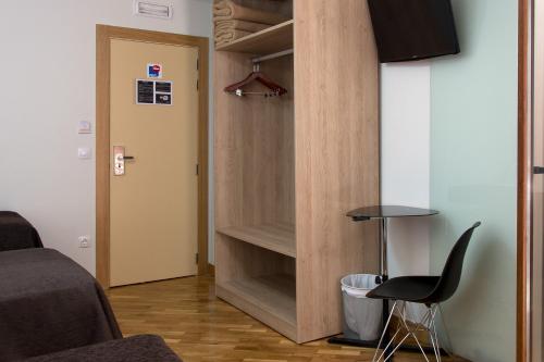 洛格罗尼奥金月桂膳食公寓的客房设有带椅子和桌子的衣柜。
