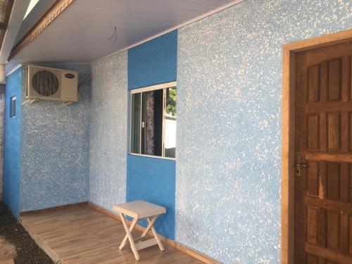 伊瓜苏阿康切戈住宿加早餐旅馆的一间设有窗户和凳子的蓝色墙壁客房