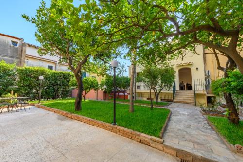 陶尔米纳Villa Valverde Apartments e B&B的一座种有树木的庭院和一座建筑