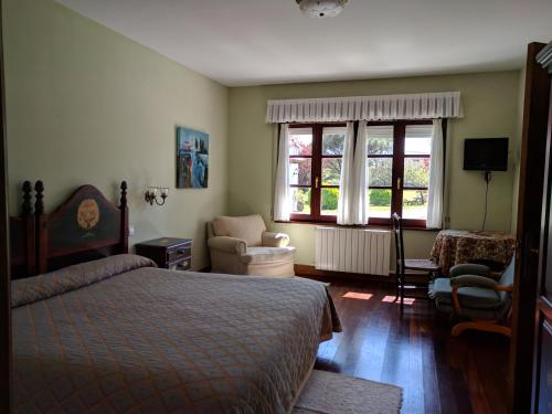 洛雷多Posada La Merced的卧室配有床、椅子和窗户。