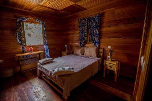 TrindadeRoça Saudade Guest House的木制客房内的一间卧室,配有一张床