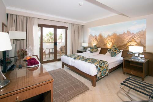 达哈布达哈布瑞士酒店的酒店客房设有一间带一张床和一张书桌的卧室