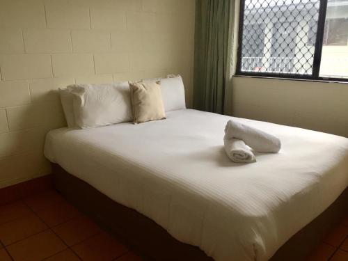 凯恩斯考拉海滩度假酒店凯恩斯店的一张白色的床,上面有一条毛巾