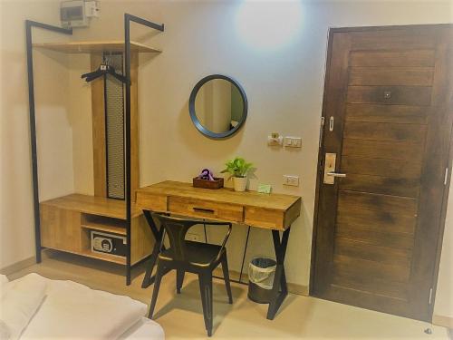 曼谷Bangkok Saran Poshtel的更衣室配有木桌和镜子