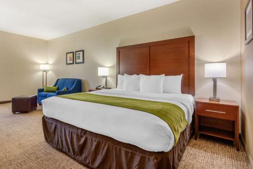 勒诺城勒诺城康福特茵酒店的酒店客房带大床和蓝椅