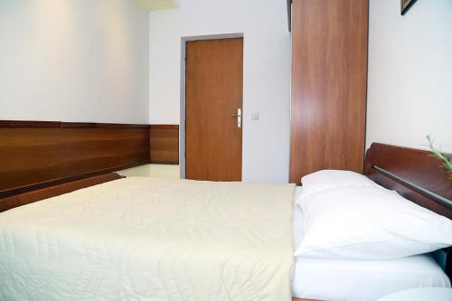 佩特罗瓦纳莫鲁阿尔杜拉公寓的卧室配有白色的床和木门