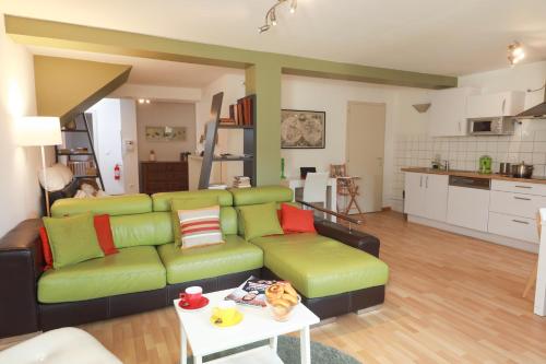 科尔马科尔马大路公寓的客厅配有绿色沙发和桌子