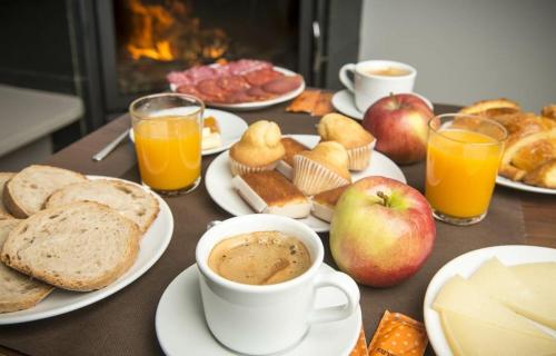 阿丰萨格拉达Hotel portico的餐桌,带早餐食品盘和咖啡杯