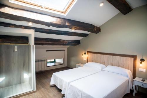 阿丰萨格拉达Hotel portico的卧室配有一张白色的大床和天窗。