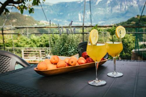 特雷莫西内Casa Federico的一张桌子,上面放着一碗水果和两杯葡萄酒