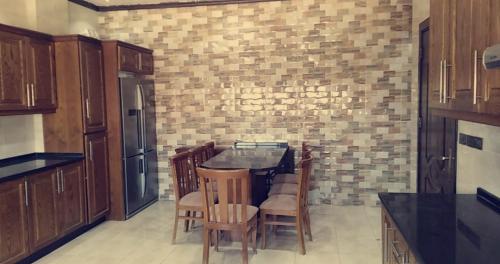 瓦迪穆萨Petra Villa的厨房配有桌椅和砖墙
