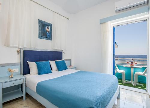 帕琉乔拉Klima Rooms的卧室配有蓝色和白色的床和窗户。