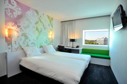 埃因霍温埃因霍温机场郁金香酒店的酒店客房设有白色的床和窗户。