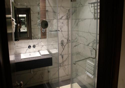 贾朗达尔AB Clarks Inn Jalandhar的带淋浴、水槽和镜子的浴室