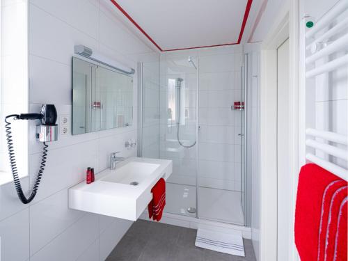 勒沃库森Landhotel Fettehenne的白色的浴室设有水槽和淋浴。