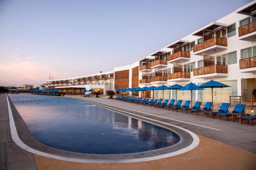 帕拉卡斯圣奥古斯丁帕拉卡斯酒店的酒店设有带椅子和遮阳伞的游泳池