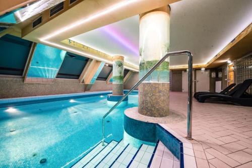 蒂黑Piramida Park Hotel & Wellness的游泳池,位于带游泳池的建筑内