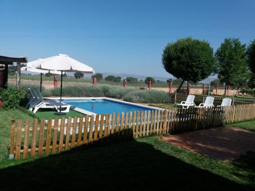 Arenas de San JuanLos Mentideros的游泳池旁的围栏,带椅子和遮阳伞