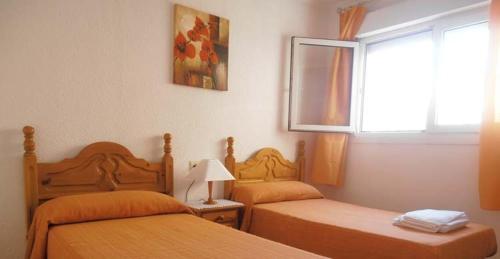 滨海罗克塔斯Apartroquetas的一间卧室设有两张床和窗户。