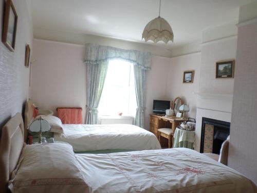布兰普顿Hullerbank的一间卧室设有两张床和窗户。