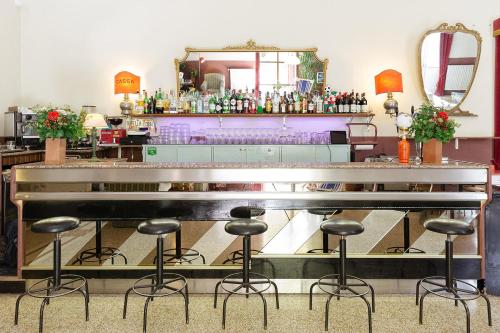佛罗伦萨Ostello Tasso的一间酒吧,房间中间有凳子