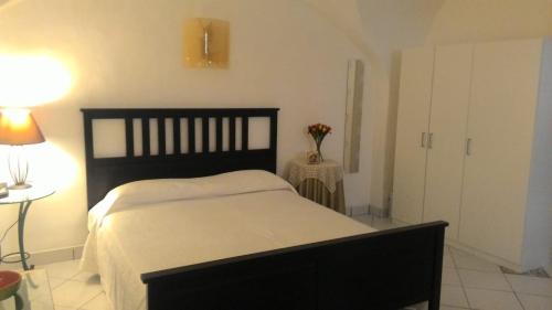 比亚恩卡维拉Casa Vacanze Gaia的一间卧室配有一张床和一张带台灯的桌子