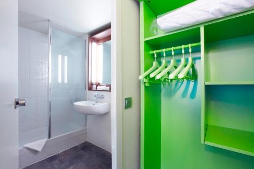 欧什坎姆盘奈奥彻酒店的浴室设有绿色的墙壁、水槽和淋浴。