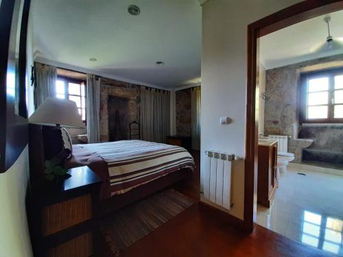 蒙塔莱格里Casa do Cerrado的一间卧室配有一张床,浴室设有浴缸