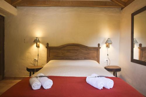 埃尔米瓜Casa Rural Los Patos的一间卧室配有一张床,上面有两条毛巾