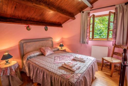 卡斯特罗波尔Casa de Aldea el Ferreirón的一间卧室配有一张粉红色墙壁的床