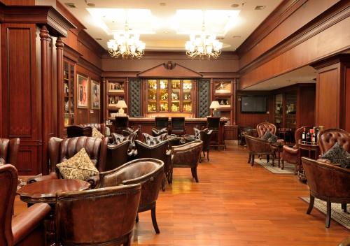 广州广州维多利酒店的一间在房间内配有皮椅和桌子的餐厅