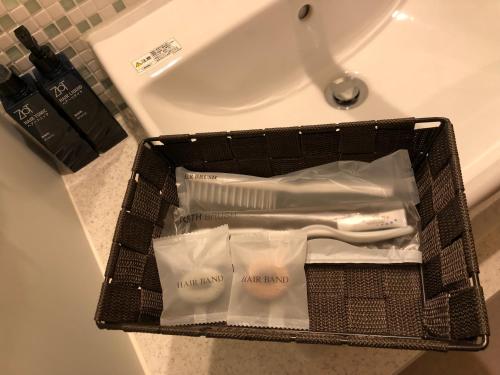 热海汤河原纽威尔西提日式旅馆的水槽上带牙刷和牙膏的篮子