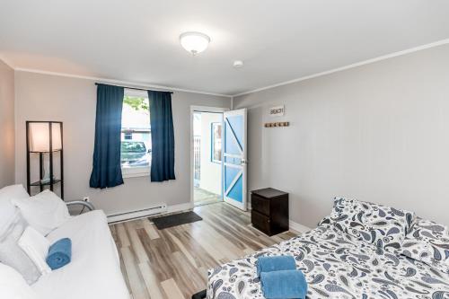 沃萨加比奇海滩Beachfront at Beach1 Motel的一间卧室配有床和蓝色窗帘的窗户