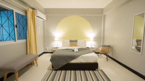 曼谷内维尤尊贵公寓：拉查达的卧室配有床、椅子和窗户。