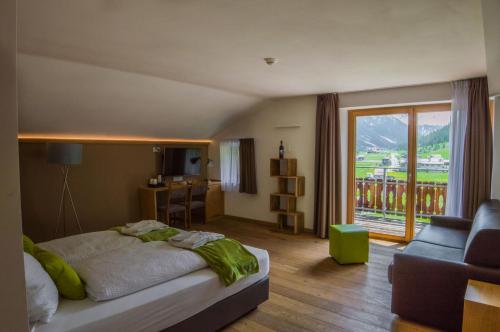 利维尼奥Sport Hotel的一间卧室配有一张床、一张沙发和一个窗口
