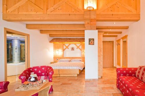 佩伊奥阿尔伯格圣洛克酒店的一间卧室配有一张床和一张红色的沙发