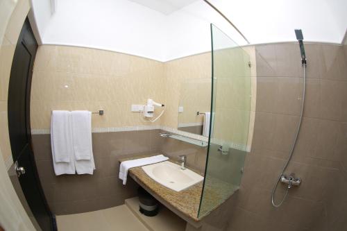 尼甘布3R Resort的一间带水槽和玻璃淋浴的浴室
