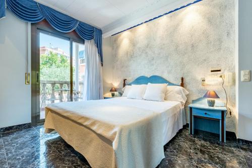 塔拉戈纳卡拿大酒店的一间卧室设有一张大床和一个大窗户
