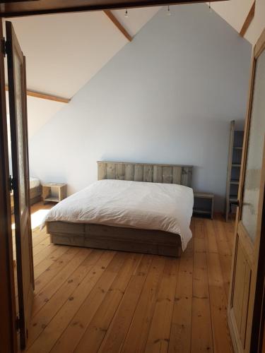 StratendriesVilla Germaine的一间卧室配有一张床,铺有木地板