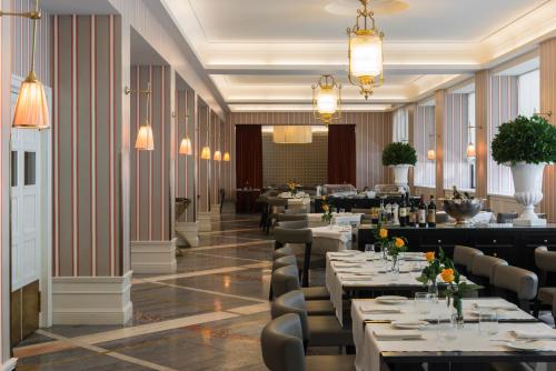 罗马星际米开朗基罗罗姆酒店的餐厅设有桌椅和吊灯。