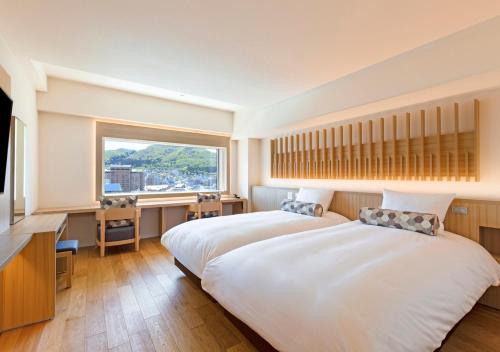 函馆HOTEL＆SPA CENTURY MARINA HAKODATE的一间卧室设有两张床和大窗户