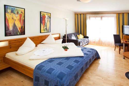毛特恩多夫宾格尔酒店的一间卧室配有一张带蓝色毯子的大床