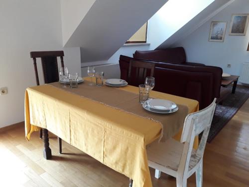 卢布尔雅那Apartma Dolomiti的餐桌上摆放着黄色桌布