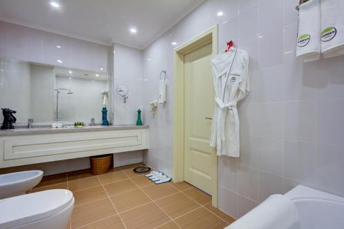 比什凯克Garden Hotel & SPA的一间带水槽、卫生间和镜子的浴室