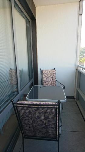 萨尔布吕肯Suite Olivier的一张椅子坐在阳台上,配有桌子
